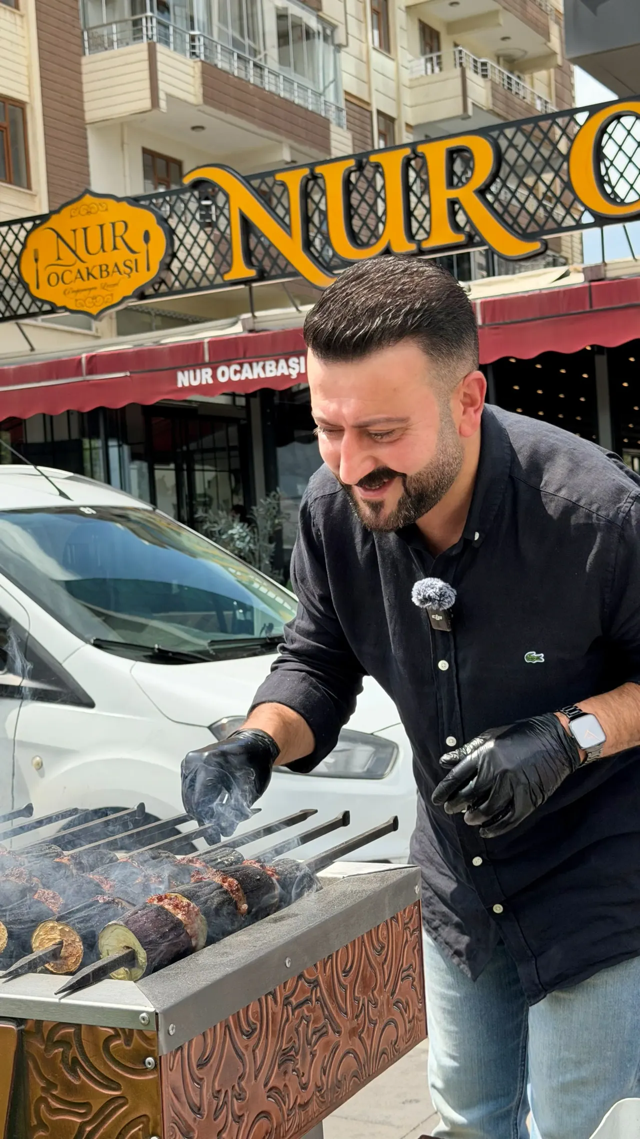 Aşçı, Nur Ocakbaşı tabelasının önünde açık havada patlıcan kebabı közlüyor